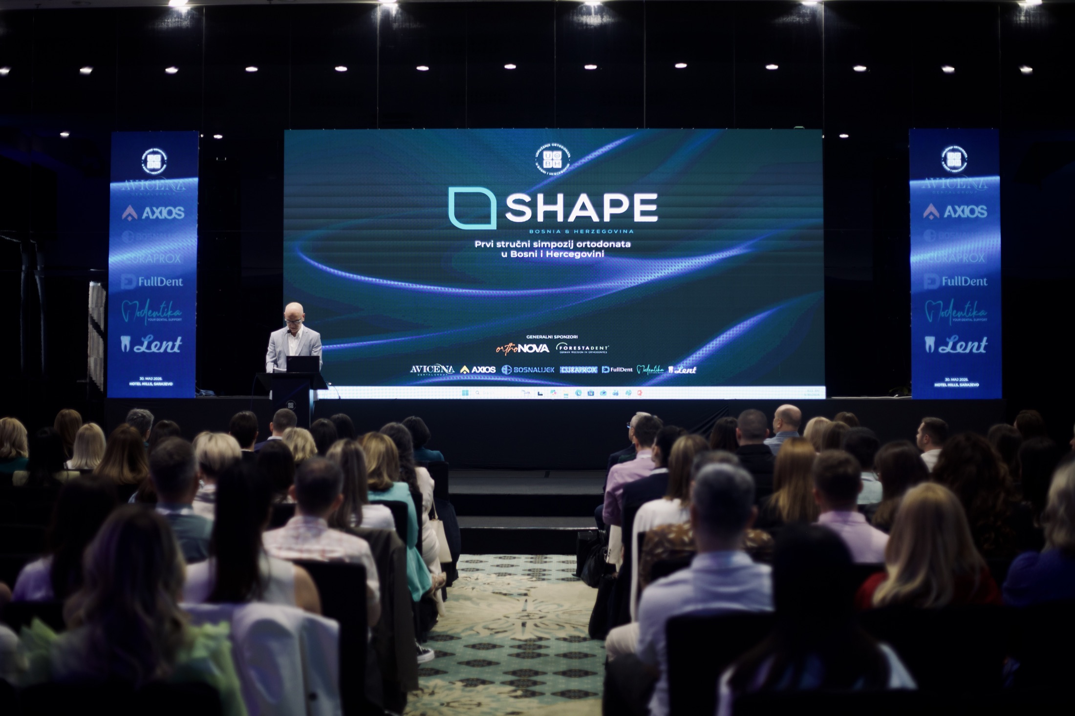 Audience and stage at SHAPE Symposium 2026